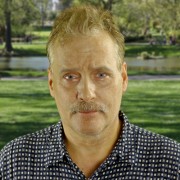 Serious-looking man with light-colored hair and mustache